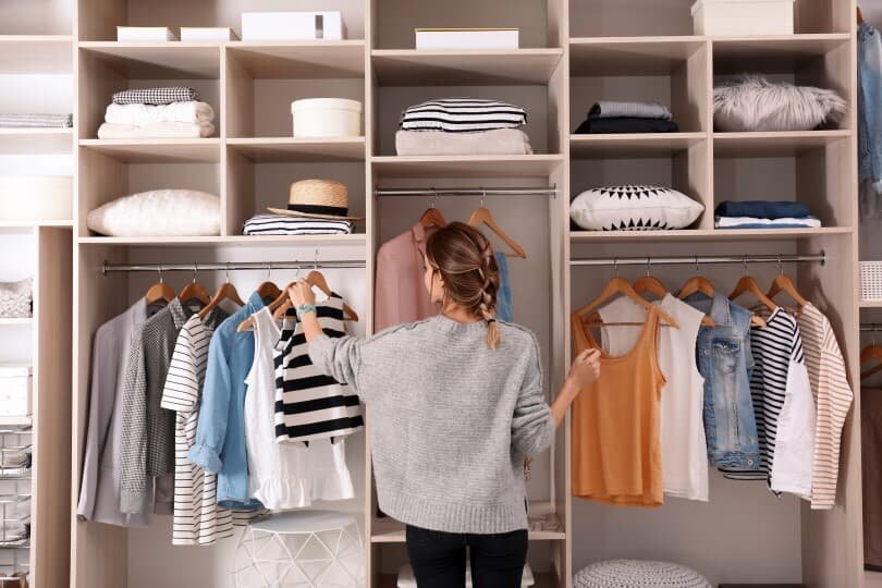 Yong woman organizing closet